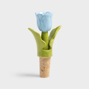 The Bottle Stopper Tulip - Blue (7 x 3.5 x 12 cm) features a cork base and a ceramic top shaped like a blue tulip with green leaves—a distinctive Estonian design, perfect for Tallinn shopping or as a unique gift. Displayed on a plain light grey background. Gate21.ee