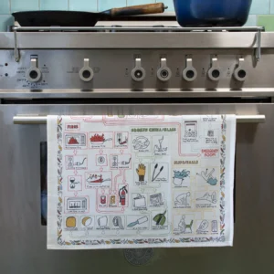 A stainless steel oven with five front control knobs displays the Kitchen Accidents – Tea Towel, known for its colourful, curated illustrations. The kitchen features a light blue tile splashback and white cupboards—ideal for Tallinn shopping inspiration. Gate21.ee