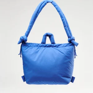 The Ona Soft Bag - Cobalt Blue is a large, padded handbag featuring a quilted texture, two short handles, and a thick knotted shoulder strap, shown here against a plain white background. Gate21.ee