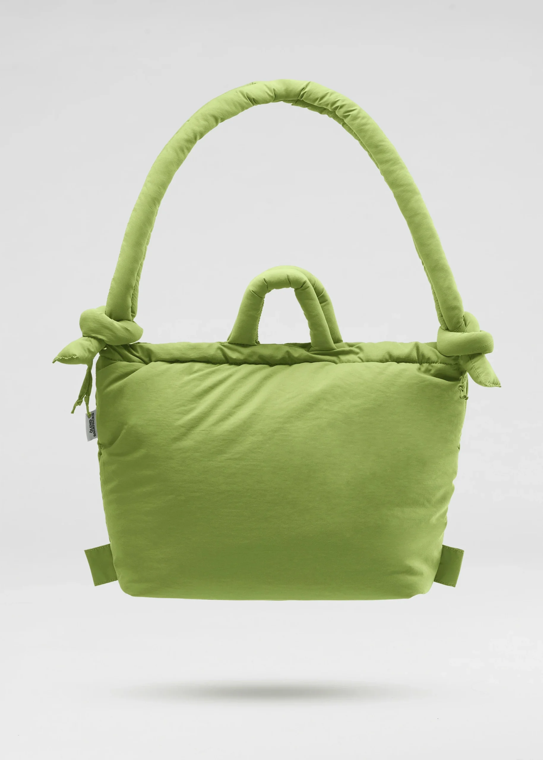 The Ona Soft Bag - Matcha is a bright green padded handbag with two short handles and a large, rounded strap featuring knotted details—perfect for Tallinn shopping or exploring concept shops. Gate21.ee