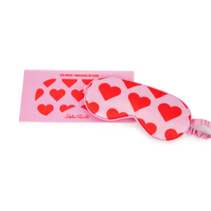 The Eye Mask - Love Dream features large red hearts on pink fabric and comes in matching curated packaging labelled "EYE MASK | MASCARA DE OJOS" and Helio Ferretti—perfect for Tallinn shopping or as a unique gift shop find. Gate21.ee