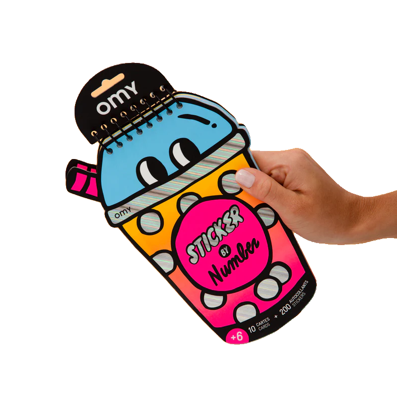 A hand holds the Bubble Tea - Sticker by Number & Postcards, a spiral-bound sticker book shaped like a cute cartoon drinks cup with eyes and pink straw—great for ages 6+ and packed with creative sticker fun. Gate21.ee