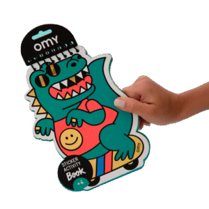 A hand holds the Dino - Sticker Activity Book & Postcards, shaped like a cartoon green dinosaur in sunglasses riding a skateboard—an original Tallinn shopping find or a unique concept shop gift idea. Gate21.ee