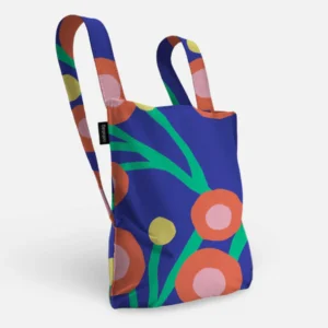 The Blossom - Special Edition is a reusable tote bag with a blue background and bold abstract floral patterns in orange, pink, green, and yellow—ideal for Tallinn shopping or carrying finds. It stands upright with visible handles against a white backdrop. Gate21.ee