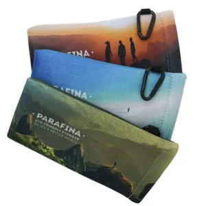 Three rectangular, soft fabric Sunglasses Cases with outdoor landscape designs and small black carabiners. The top is orange, the middle blue, the bottom green, all labelled PARAFINA—an ideal pick for any Tallinn shopping or concept shop. Gate21.ee