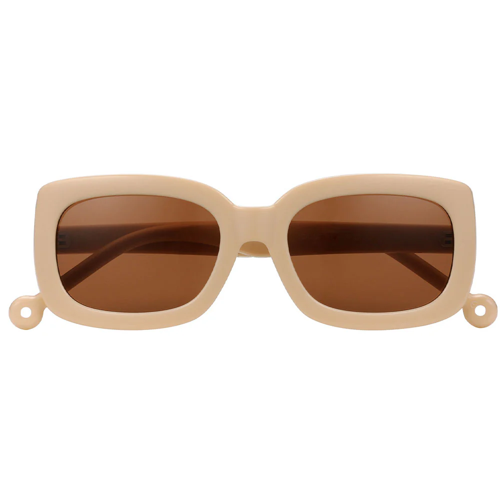 The "Duna" Creamy Sunglasses feature thick beige rectangular frames, brown tinted lenses, and small circular accents at each lower corner—ideal for anyone seeking a uniquely stylish eyewear choice. Gate21.ee