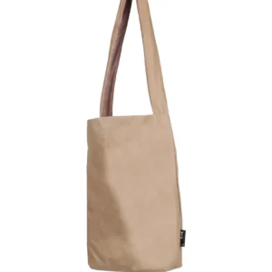 The Feel Good Bag - Porcini is a plain beige tote with a wide, long strap and black side label. Its minimalist design and neutral tone make it an ideal stylish accessory or curated find from your Tallinn shopping trip. Gate21.ee