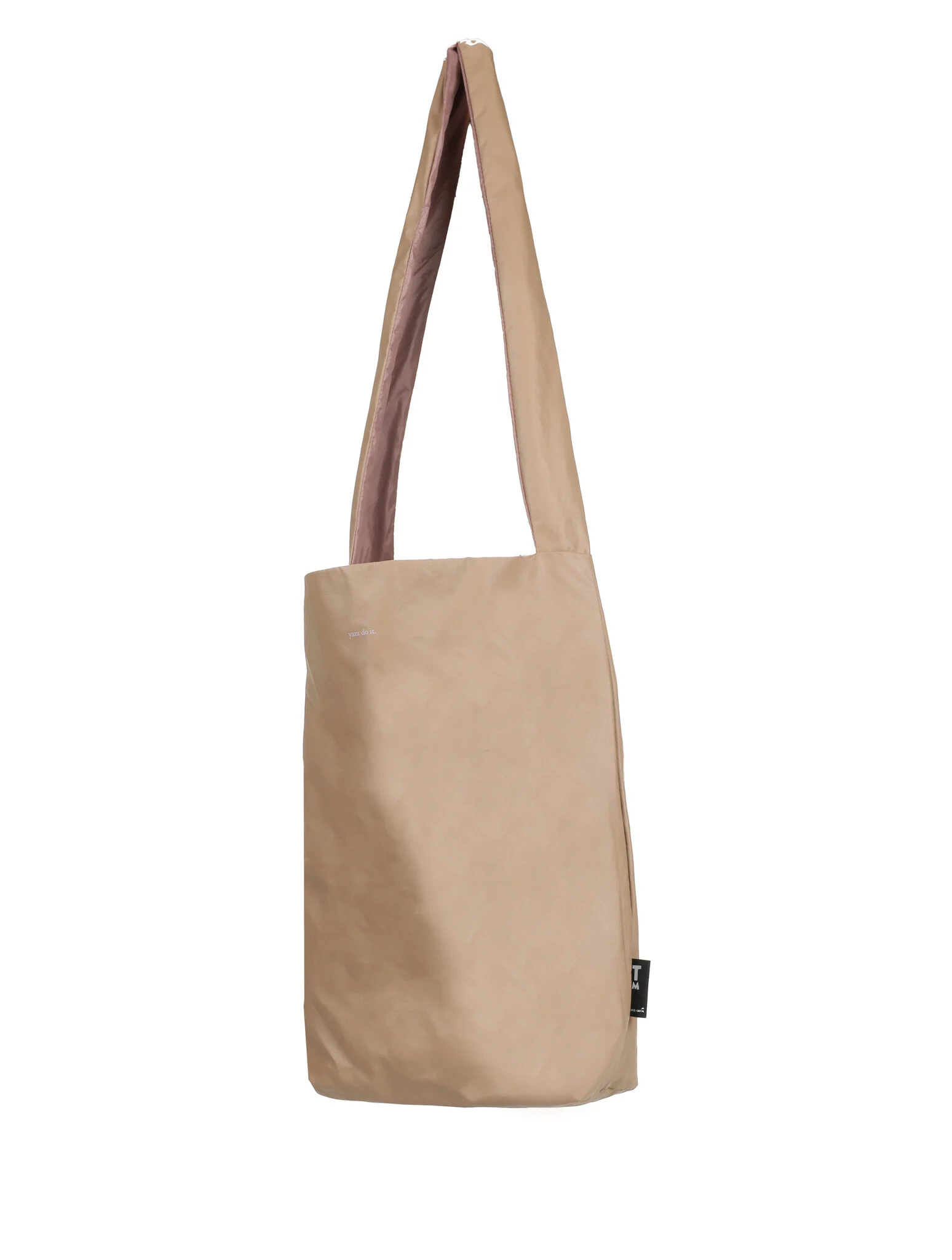 The Feel Good Bag - Porcini is a plain beige tote with a wide, long strap and black side label. Its minimalist design and neutral tone make it an ideal stylish accessory or curated find from your Tallinn shopping trip. Gate21.ee