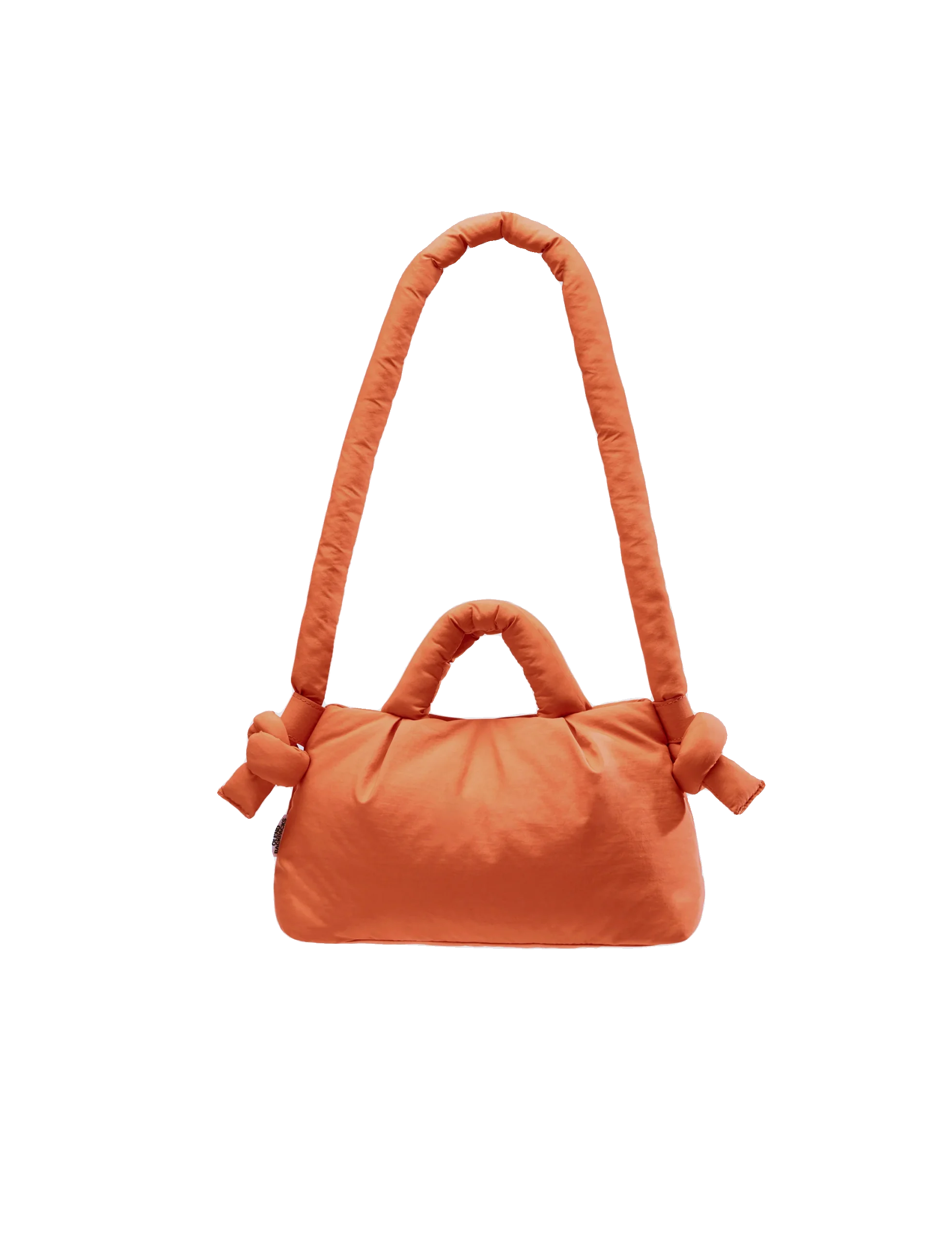 The Mini Ona Soft Bag - Oxide is a soft, rectangular orange bag with two padded handles (one short, one long) and decorative fabric knots on each side, shown against a white background—perfect for stylish shopping or as a chic present. Gate21.ee