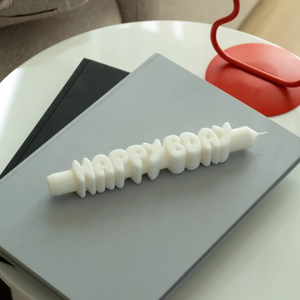 The Happy Bday 3D Candle - White, designed in bold letter shapes, adds a playful and stylish touch to any curated gift shop or concept store display. Gate21.ee