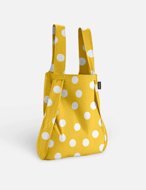 The Golden Dots - Notabag is a yellow reusable shopping bag with white polka dots, two sturdy handles, and a small black label—reflecting Estonian design and ideal for gift shop collections. Gate21.ee
