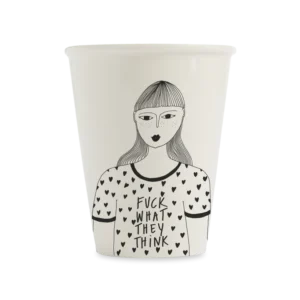 The F*ck What They Think cup features a black and white illustration of a woman with straight hair and fringe, wearing a heart-patterned shirt with the bold text "FUCK WHAT THEY THINK." A unique piece of Estonian design. Gate21.ee