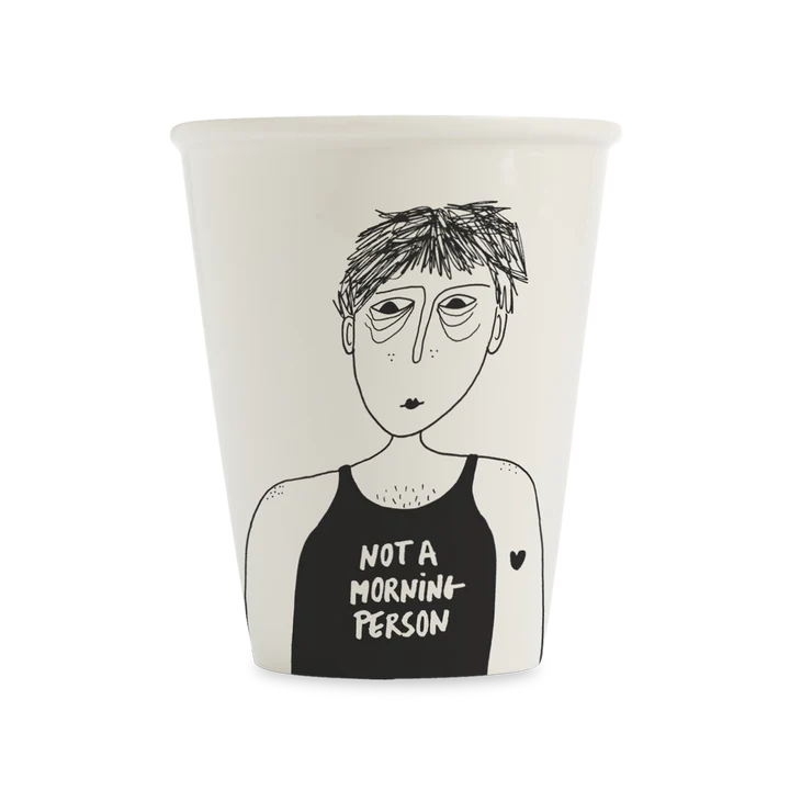 The Not a Morning Person cup features a black line drawing of a tired figure with messy hair and droopy eyes in a NOT A MORNIN PERSON vest—an ideal unique gift for concept shop shoppers. Gate21.ee