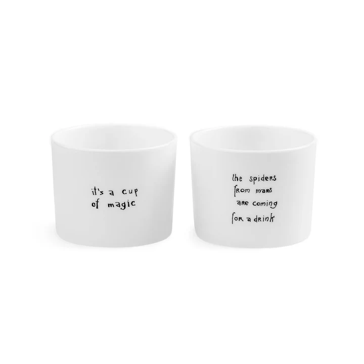 The Legends Espresso set features two white ceramic cups with black handwritten text—one reads "it's a cup of magic," the other, "the spiders from mars are coming for a drink." Both cups have a minimalist design with only text. Gate21.ee