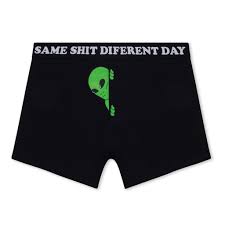 Same Shit Different Day Boxers - Black: These black boxer shorts feature a humorous waistband slogan and a playful green alien illustration—an original Estonian design, perfect for anyone seeking unique gift shop finds with personality. Gate21.ee