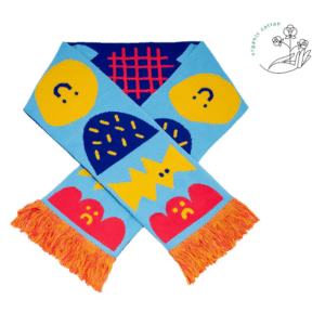 Moodies - Organic is a vibrant scarf with blue, yellow, and red abstract shapes and faces, orange fringe, and a white background. Made from organic cotton, it’s a unique accessory perfect for Tallinn shopping or as a special gift shop find. Gate21.ee