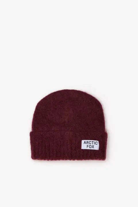 The Mohair Beanie - Cherry Burgundy is a maroon knitted beanie with a folded brim and a white rectangular ARCTIC FOX patch on the front, displayed against a plain white background. Gate21.ee