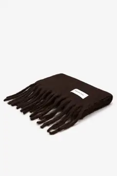 The Reykjavik Scarf - Ground Coffee is displayed folded with fringed ends and a white rectangular label, set against a plain white background. Gate21.ee