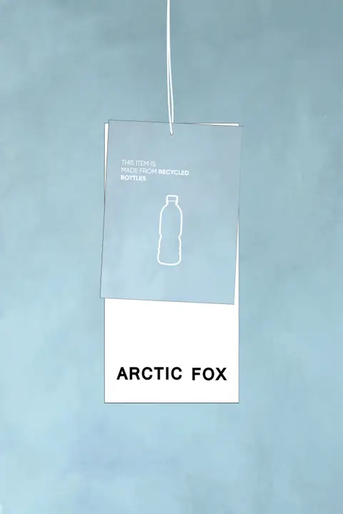 Two hanging cards on a light blue background: the top card features a bottle outline with "THIS ITEM IS MADE FROM RECYCLED BOTTLES," whilst the lower card displays "The Reykjavik Scarf - Nordic Skies" in bold black letters. Gate21.ee