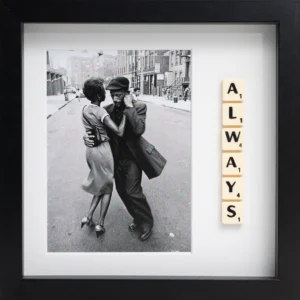 The ALWAYS - Scrabble Print features a black-and-white photo of a couple dancing on a city street with Scrabble tiles spelling "ALWAYS" on the right, all set in a black frame—a perfect piece to spark cherished memories. Gate21.ee