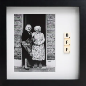 BI POLAR - Scrabble Print: Black and white photo of two elderly women smiling in a doorway, with three Scrabble tiles spelling BFF arranged vertically in a black frame—perfect for sparking memories or celebrating special occasions!. Gate21.ee