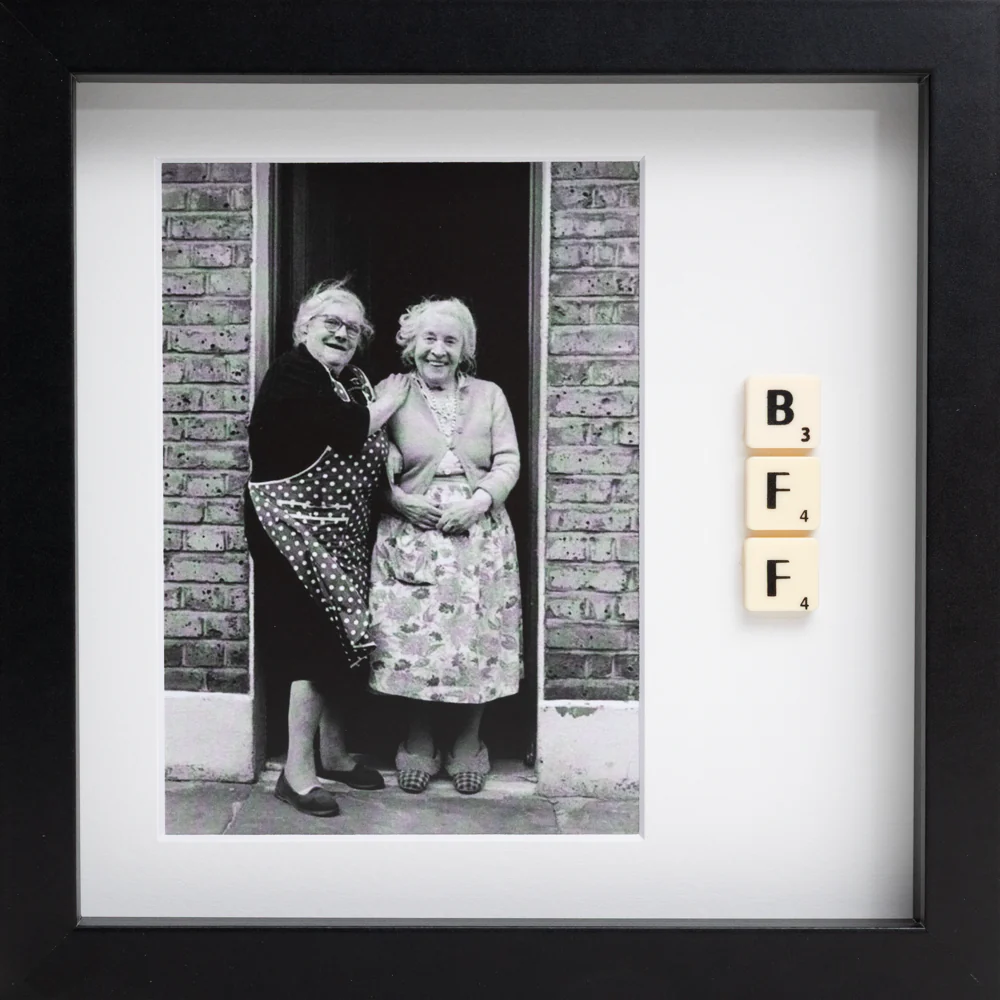 BI POLAR - Scrabble Print: Black and white photo of two elderly women smiling in a doorway, with three Scrabble tiles spelling BFF arranged vertically in a black frame—perfect for sparking memories or celebrating special occasions!. Gate21.ee