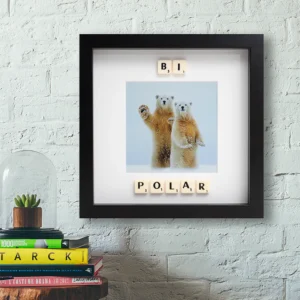 The BI POLAR - Scrabble Print features two polar bears standing upright, with Scrabble tiles spelling "BI POLAR" and a stylish frame perfect for displaying on your wall or shelf. Gate21.ee