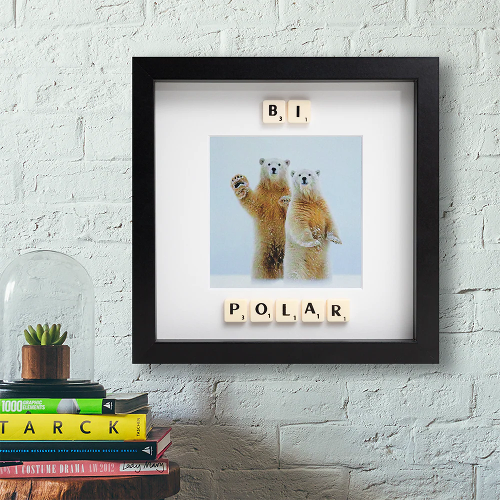 The BI POLAR - Scrabble Print features two polar bears standing upright, with Scrabble tiles spelling "BI POLAR" and a stylish frame perfect for displaying on your wall or shelf. Gate21.ee