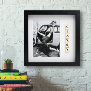 The "CLASSY - Scrabble Print" features a black-and-white photo of a person half in a car with legs and arm on the ground, next to Scrabble tiles spelling CLASSY—a perfect piece for sparking memories or cherished moments. Gate21.ee