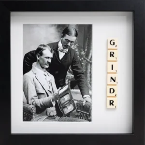 A black-and-white photo of two men in vintage attire sits within a black frame, with Scrabble tiles vertically spelling "GRINDR"—the GRINDR - Scrabble Print is designed to spark memories or highlight meaningful moments. Gate21.ee