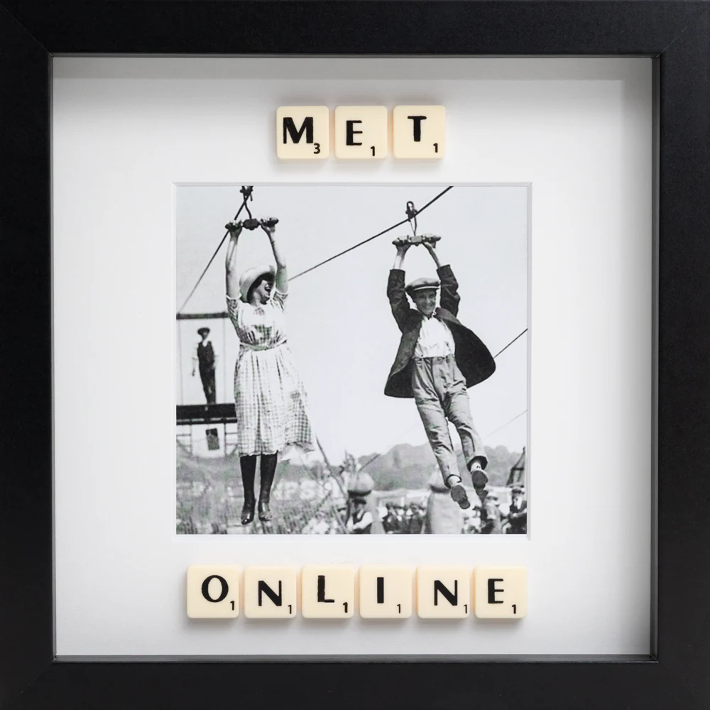The MET ONLINE - Scrabble Print features a black-and-white photo of a woman and man on a zipwire, framed by Scrabble tiles spelling "MET ONLINE"—a perfect way to celebrate a memorable moment. Gate21.ee