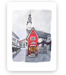 A small red building with glowing yellow windows stands in front of a larger white church with a tall spire. “Fuck - Tea-towels” hang in the window, adding a cosy touch to the quiet street scene beneath the overcast skies. Gate21.ee