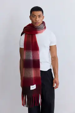 A person stands against a plain background, wearing a fitted white t-shirt, black trousers, and The Reykjavik Scarf - Burgundy Check wrapped around the neck and draped down the front. Gate21.ee