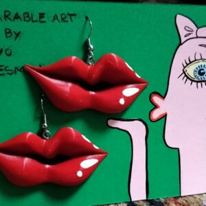 The Riivo 3D suur k&otilde;rvar&otilde;ngas features red, lip-shaped earrings on a green card with a cartoon of a pink face, one big eye, puckered lips, and handwritten text at the top. Gate21.ee