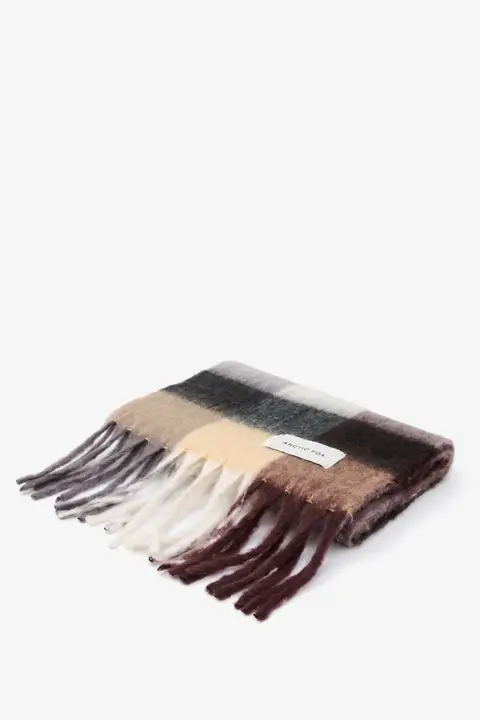 The Reykjavik Scarf - Purple / Brown is a folded scarf with long fringes, horizontal stripes in purple and brown tones, and a rectangular white label attached. Gate21.ee