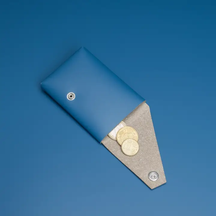 A LEMUR - Blue Wallet with a press-stud fastening is open to show coins inside, set against a solid blue background. Gate21.ee