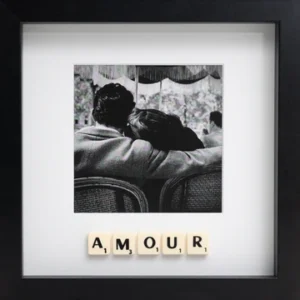 The LOVE - Scrabble Print features a black and white photo of a couple sitting close, viewed from behind, with Scrabble tiles spelling "AMOUR" beneath&mdash;framed in a black square to remind you of love&rsquo;s special moments. Gate21.ee