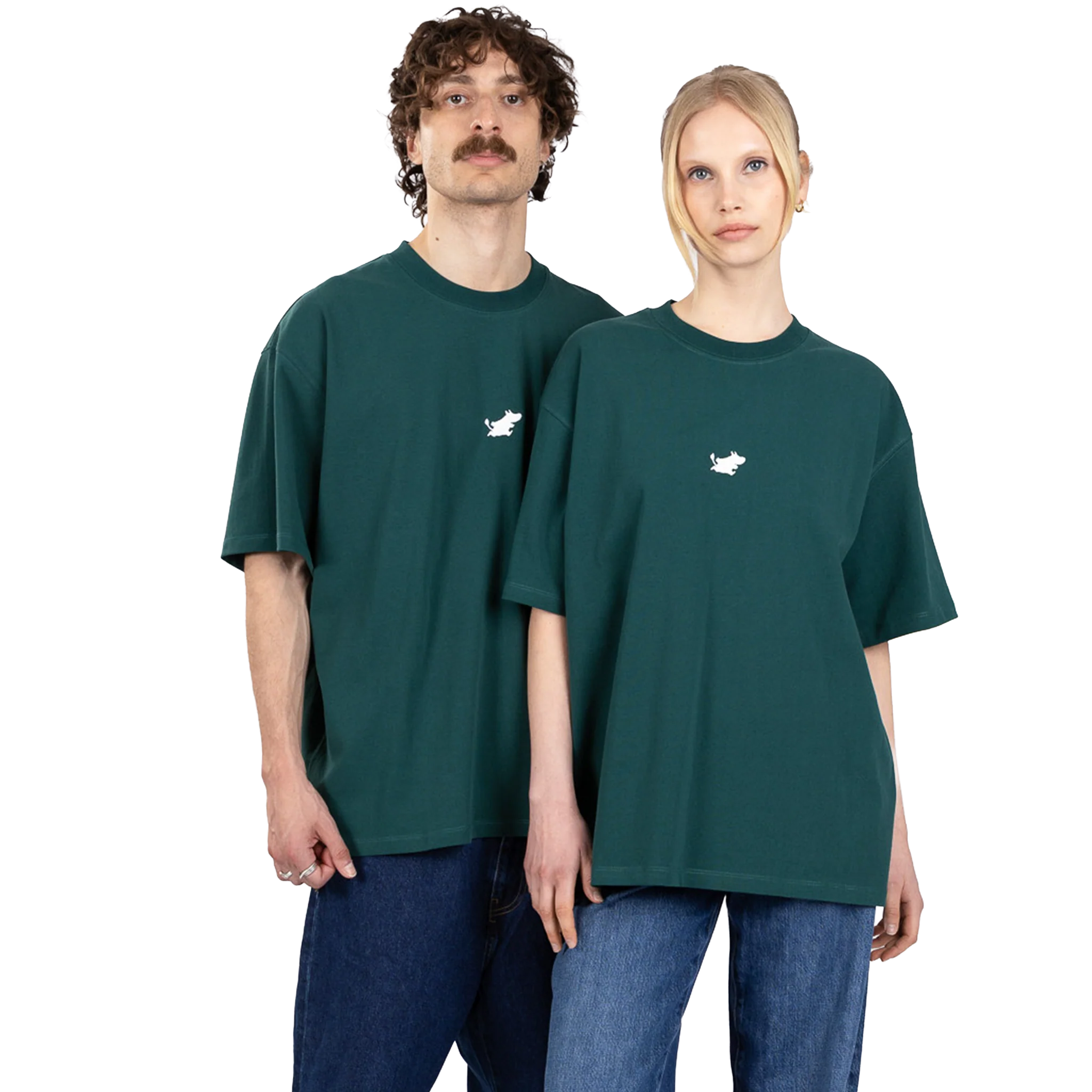 A man and a woman stand side by side, both wearing oversized green Moomin Heavy Ts with a small white graphic on the chest and blue jeans. The background is plain white. Gate21.ee