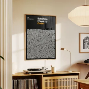 A Bohemian Rhapsody - Lyrics Poster in a black and white abstract frame hangs above a wooden cupboard displaying a record player, lamp, and books in a modern, softly lit room. Gate21.ee