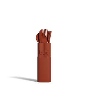 The Bini Cutlery Kit - Terracotta features a rust-coloured, portable set with a fork, spoon, knife, and chopsticks standing upright in a matching rectangular case against a plain white background. Gate21.ee