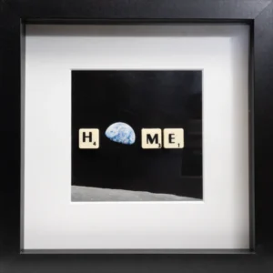 The HOME - Scrabble Print features Scrabble tiles spelling H _ M E, with Earth's photo from the Moon as the background. The blank tile is the O, forming "HOME"—a unique addition sure to evoke memories and special moments. Gate21.ee
