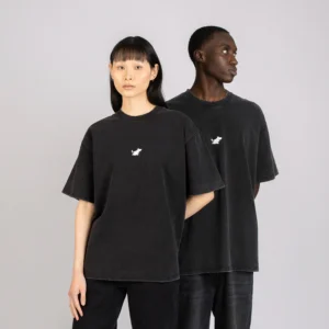 Two people stand side by side against a light grey background, both wearing oversized Moomin T-shirts - Stone Wash Black with a small white chest graphic and neutral expressions. Gate21.ee