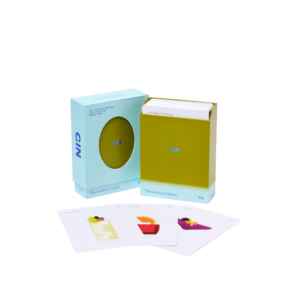 A box labelled "The Cocktail Cabinet: Gin" with partially inserted cards sits beside three playing cards, each featuring a minimalist cocktail recipe illustration, all on a plain white background. Gate21.ee