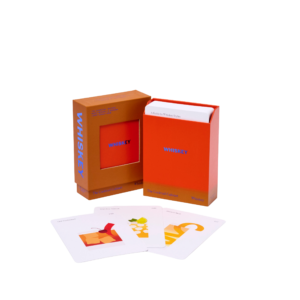 The Cocktail Cabinet: Whisky is displayed in an orange and red box with a stack of cards inside. Three illustrated cocktail recipe cards are spread out in front of the box on a white background. Gate21.ee