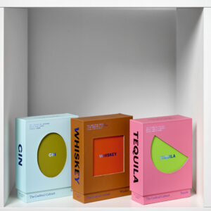 A vibrant box labelled "The Cocktail Cabinet: Tequila" sits on a white shelf, featuring a bold design with an eye-catching cut-out&mdash;perfect for storing your favourite cocktail recipes in style. Gate21.ee