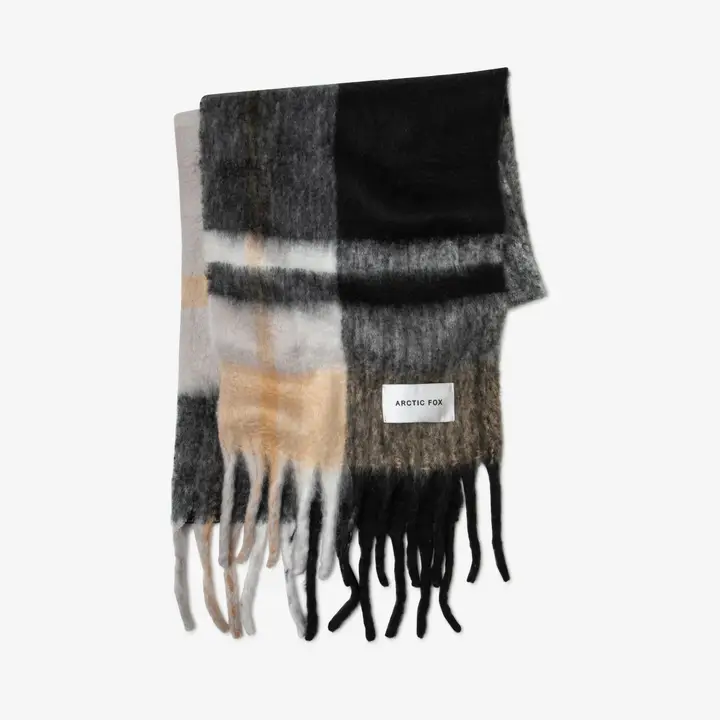 The Stockholm Scarf - The Arctic is a rectangular scarf with a large black, grey, white, and beige check pattern, long fringe on both ends, and a sewn Arctic Fox Stockholm label. Gate21.ee