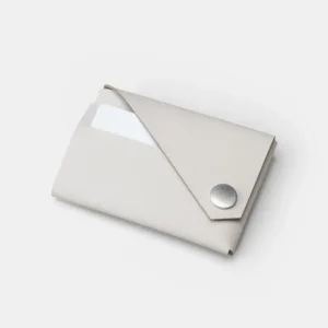 A minimalist LEMUR - White Wallet with a metal press-stud fastening and a card partially visible inside, displayed on a plain white background. Gate21.ee