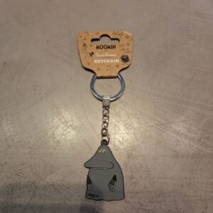 A Moomin Keyring - Gnork featuring a grey Gnork figure attached to a silver chain and ring, displayed on a grey surface. Ideal for collectors of Moomin keyrings, the packaging reads: MOOMIN Nordicbuddies KEYRING. Gate21.ee