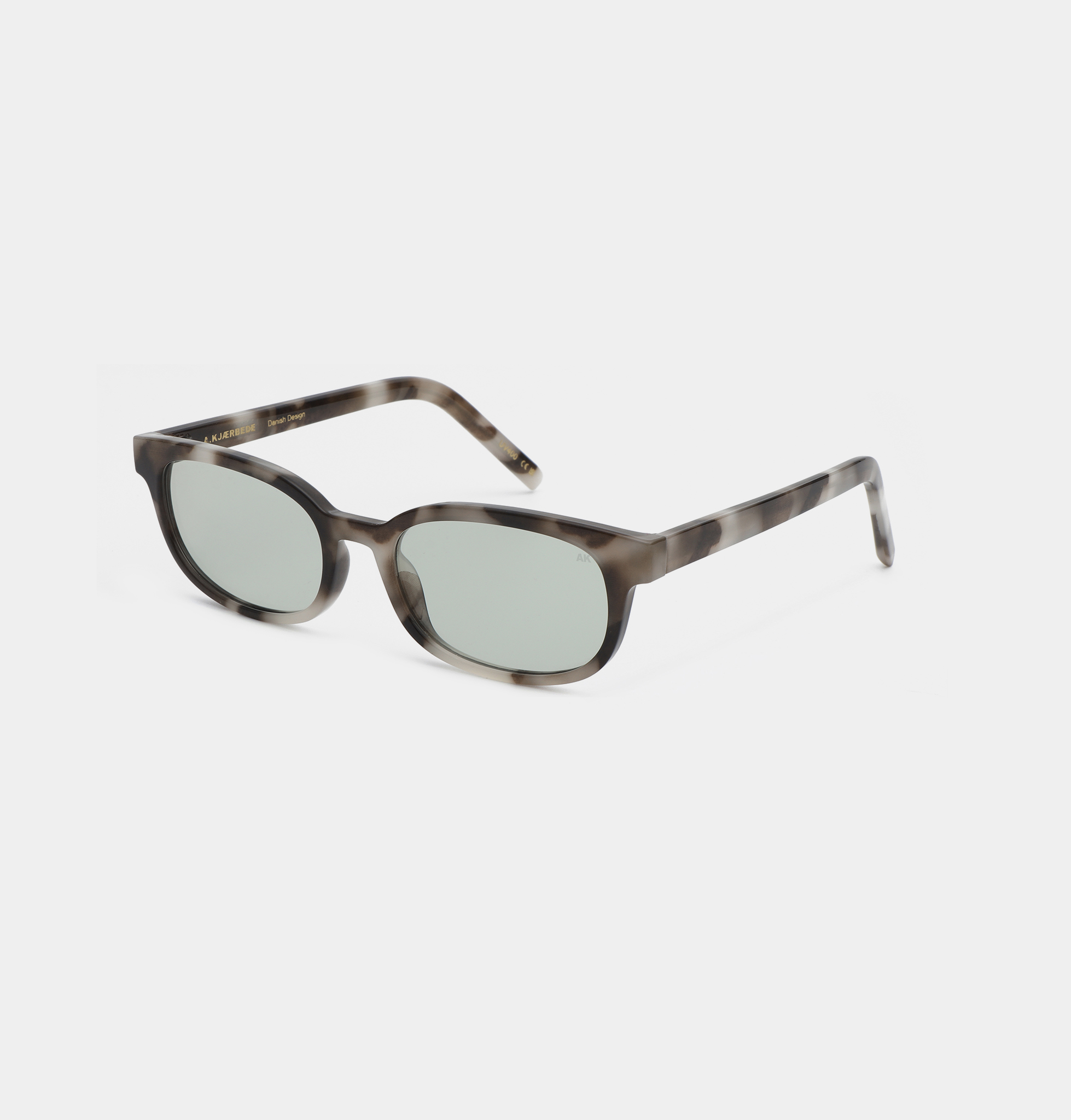 The A. Kjærbede Charlie - Cookie Dough sunglasses feature oval-shaped, light grey lenses and a marbled brown and black frame, displayed on a plain white background. Gate21.ee