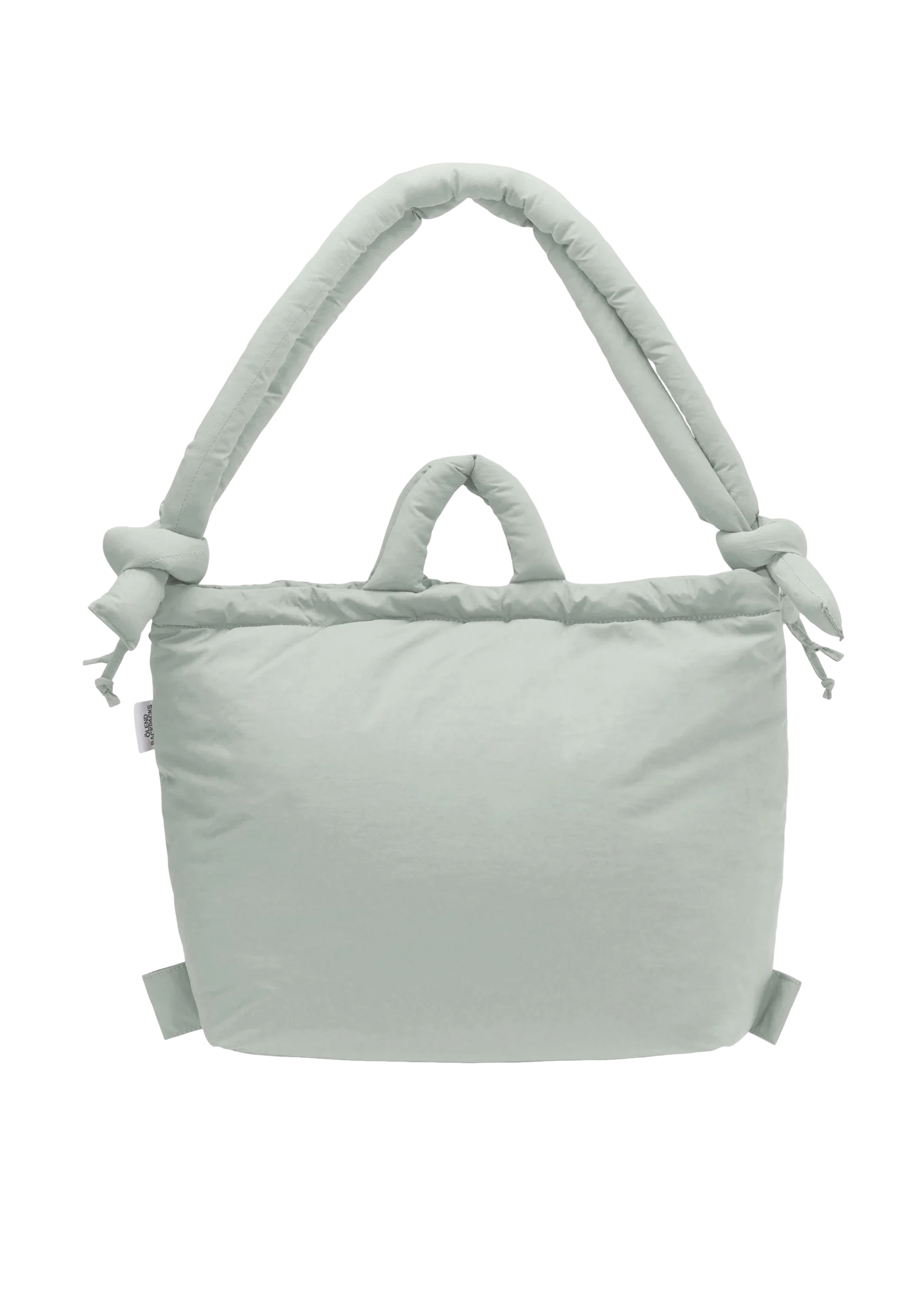 The Ona Soft Bag - Pearl Grey is a light grey, rectangular bag featuring padding, two small handles, and a large, thick knotted shoulder strap. The design is plain with no visible patterns or logos. Gate21.ee